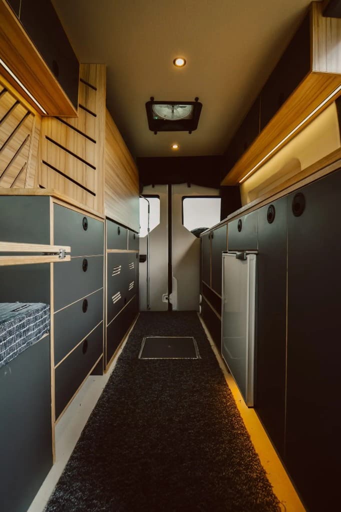 YAKKT van build interior with dark cabinets and timber accents